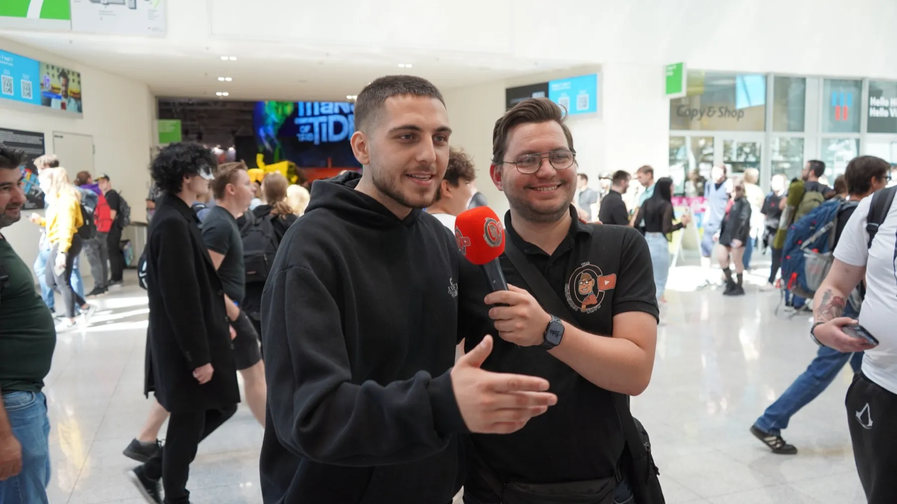 Christian im Interview mit dem roten Christienco-Mikrofon in einer Messehalle