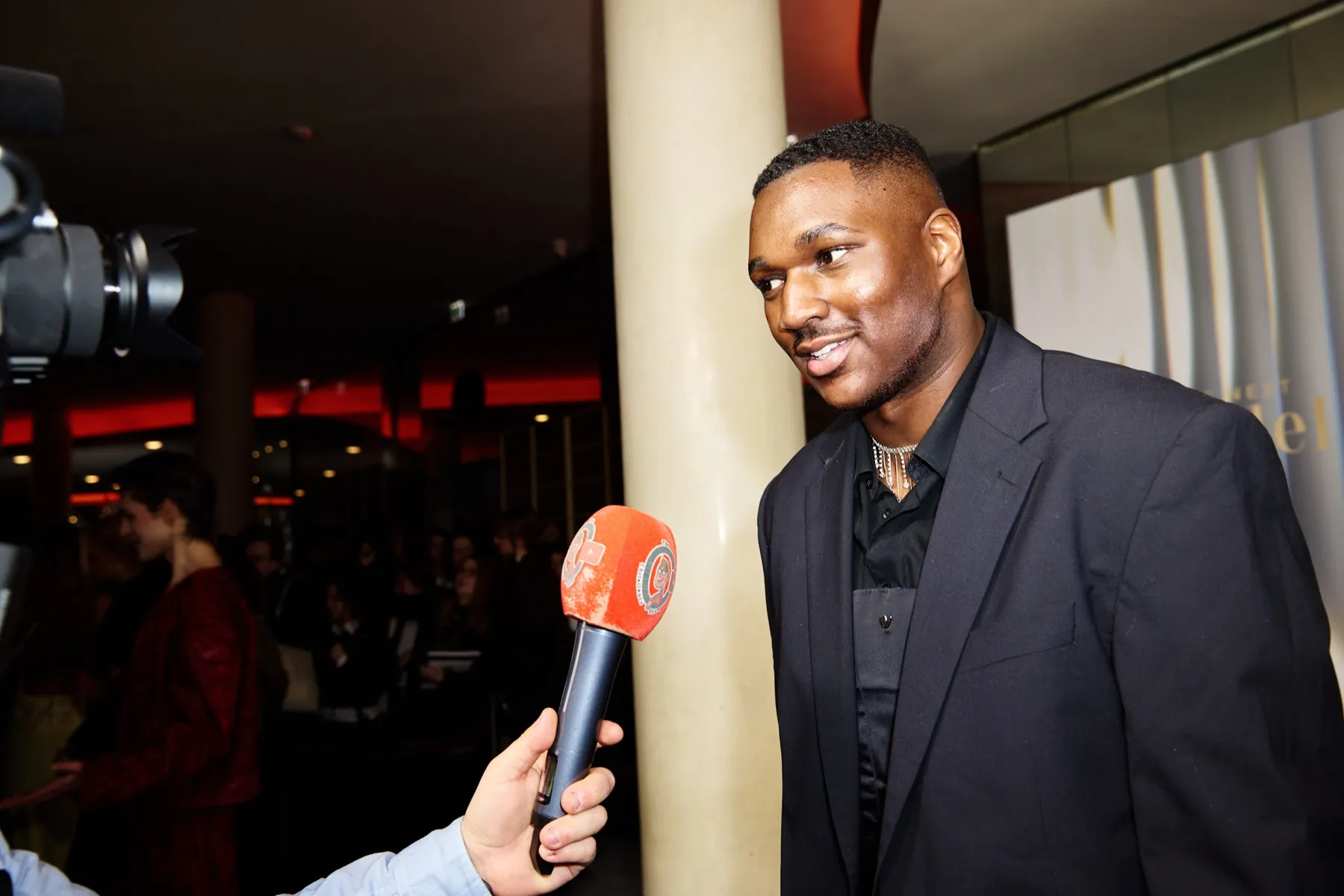 Red-Carpet-Interview mit einem Gast im dunklen Anzug